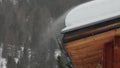 snow blowed by the wind on wooden hut roof slow motion