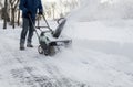 Snow blower in action clearing a residential driveway after snow storm