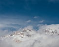 a snow boarder in mid - air above clouds and mountains