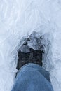 A snow boot close up shot of a ice shoe standing and walking in fresh white powder snow. the ice is clean and cold looking. The Royalty Free Stock Photo