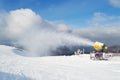 Snow cannon machine blowing artificial snow on Azuga ski domain, Prahova Valley region, Romania, during the Winter low season. Royalty Free Stock Photo