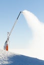 Snow cannon making artificial powder at the very top of a ski slope Royalty Free Stock Photo