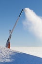 Snow cannon making artificial snow powder on a mountain ski slope