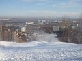 Snow cannon preparing a slope to ski in the background of the urban landscape