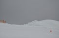 A snow cannon snowed a giant pile of snow. it has a plastic fence and a cone used on the roads. horizon snowboard jump