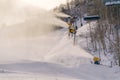 Snow cannons and ski lifts on snowy mountain slope Royalty Free Stock Photo