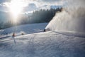 Snow cannons working on ski slope in Alps at sunny day