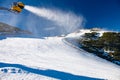 Snow canon is covering slope in ski resort with fresh snow Royalty Free Stock Photo