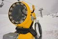 Snow canon at ski resort with mountains on background