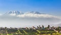 Snow capes of chachani Volcano over the fields and houses of peruvian city of Arequipa