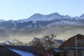 Snow-capped high mountains of the Trans-Ili Alatau during the winter daytime above a residential area of the town