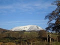 Snow capped hill stands out against the blue winter skies