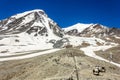 Snow capped Himalayan mountains towering above horses grazing