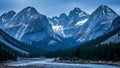 Snow-capped mountain range with a winding river in the foreground and dense evergreen forest Royalty Free Stock Photo