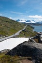 Snow capped mountains and crystal clear lakes along the Sognefjellsvegen, highest mountain road of Northern Europe