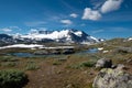 Snow capped mountains and crystal clear lakes along the Sognefjellsvegen, highest mountain road of Northern Europe