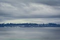 Snow-capped mountains in the icy clear winter sky sprout from a sea of clouds. Royalty Free Stock Photo