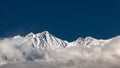 Snow-capped mountains shrouded in clouds on a sunny day, Tyrol, Austria Royalty Free Stock Photo