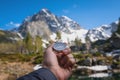 Snow-capped mountains and a tourist hand with an old metal compass in the foreground. Nature reserve, landscape Royalty Free Stock Photo