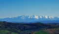 Snow-capped peaks, valleys and hills of the Apennine mountains in the blue sky of a spring day