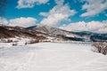 Snow-capped wooden fence in mountains Carpathians Ukraine. On background Christmas tree in forest. Winter nature. Landscape. Top