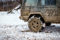 Snow chain on wheel of dirty car in snowy winter Royalty Free Stock Photo