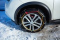 Snow chains on a car wheel close-up from side Royalty Free Stock Photo