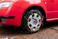 Snow chains on front wheel of Skoda Fabia car with Barum tyres after the snow has melted