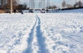 Snow in city park with footprints, winter concept on frosty sunny day