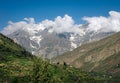 Snow cladded mountain , blue clouds and greenery in the background in Manali India