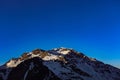 A snow cladded mountain with a clear blue sky