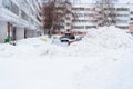 Snow cleaning in Russia. A huge pile of snow in the courtyard of an apartment building