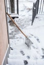 Snow cleaning shovel lean on house wall ready for cleaning entrance and stairs cold winter Royalty Free Stock Photo