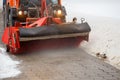 Snow cleaning. Snow removal tractor clearing snow from pavement with special round spinning brush,