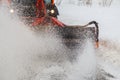 Snow cleaning. Snow removal tractor clearing snow from pavement with special round spinning brush, Royalty Free Stock Photo