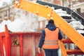 Snow cleaning tractor snow-removal machine loading pile of snow on a dump truck. Snow plow outdoors cleaning street city