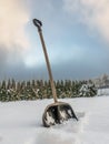 Snow clearing shovel driven into thick snow cover