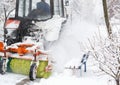 Snow clearing. Tractor clears road, way after heavy snowfall. Tractor cleaning the road from the snow. Excavator cleans the street Royalty Free Stock Photo