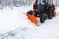 Snow clearing. Tractor clears road, way after heavy snowfall. Tractor cleaning the road from the snow. Excavator cleans the street Royalty Free Stock Photo