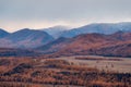 Snow clouds float over the autumn wooded mountain valley