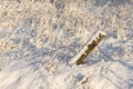 Snow-covered agricultural field with winter grass under the snow and demolished barbed wire fence Royalty Free Stock Photo