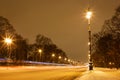 snow-covered avenue with burning lanterns on a winter evening Royalty Free Stock Photo