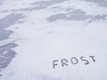 Snow-covered background with the word Frost Royalty Free Stock Photo