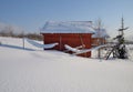 Snow-covered barn in village on sunny winter day Royalty Free Stock Photo