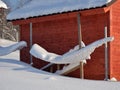 Snow-covered barn in village on sunny winter day Royalty Free Stock Photo