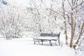 Snow covered bench in a deserted park. Winter. Russia