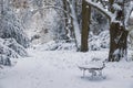 Snow covered bench and footprints on the snow in the winter park Royalty Free Stock Photo