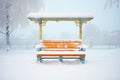 snow-covered bench in misty morning