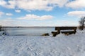 A snow covered bench with a view to the beach and River Deben at the popular visitor Bawdsey Quay on the Suffolk coast Royalty Free Stock Photo