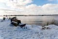 A snow covered bench with a view to the beach and River Deben at the popular visitor Bawdsey Quay on the Suffolk coast Royalty Free Stock Photo